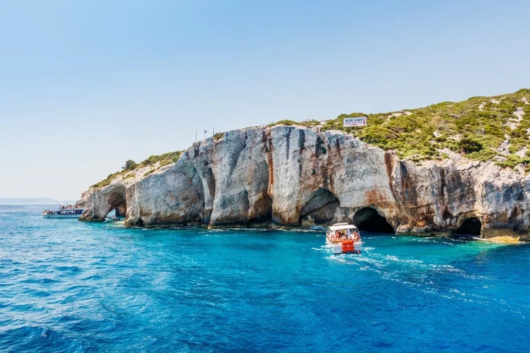 Tourist boats close to Blue caves at the cliff of Zakynthos island with, Greece